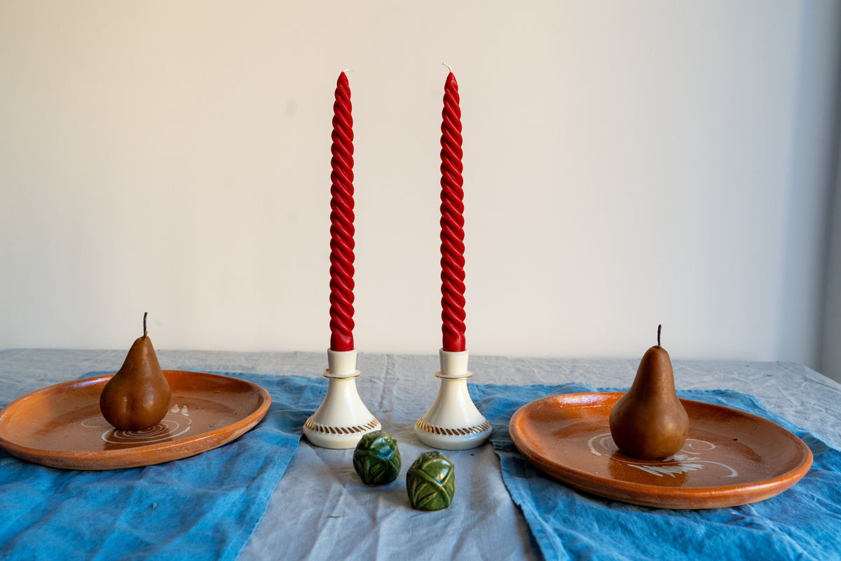 Red taper candles and pears on a holiday table